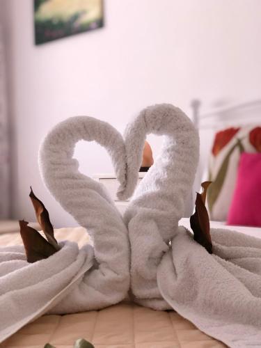 a pair of towel swans sitting on a bed at Evmorfias House in Kallirákhi