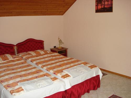 a bedroom with a large bed with a red headboard at Royal Villa in Balatonfüred