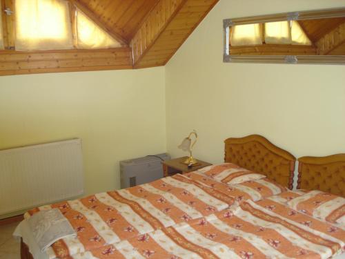 a bedroom with a bed and two windows at Royal Villa in Balatonfüred