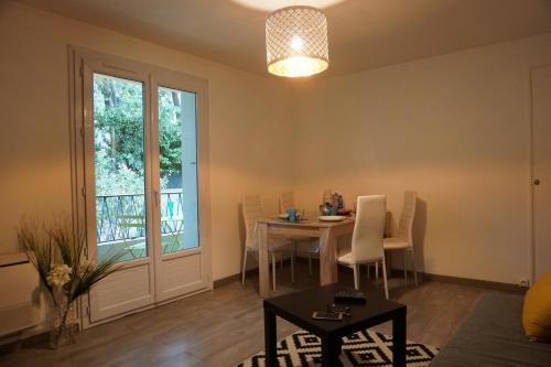 un salon avec une table et des chaises et une fenêtre dans l'établissement Bel Appartement Spacieux bien situe Parking Gratuit, à Montpellier