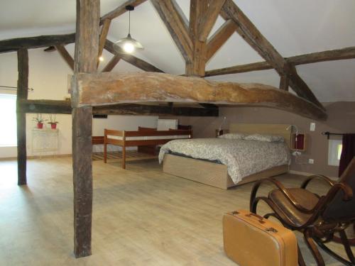 a bedroom with a bed and a table and a chair at La Maison des Graves in Pujols Gironde