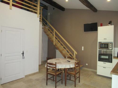 une salle à manger avec une table et un escalier dans l'établissement La Maison des Graves, à Pujols Gironde
