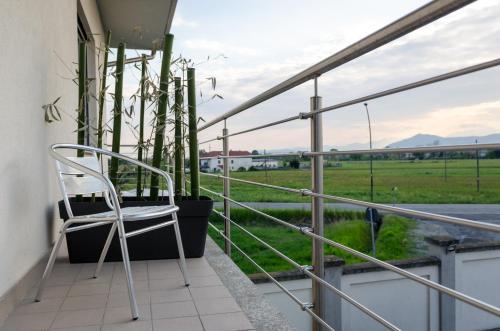 a chair on a balcony with a view of a field at La Montrucca Camere in Caselle Torinese