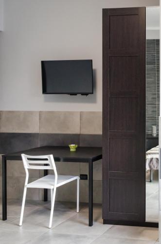 a desk with a chair and a television on a wall at La Montrucca Camere in Caselle Torinese