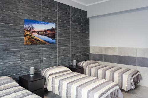 a room with three beds and a painting on the wall at La Montrucca Camere in Caselle Torinese