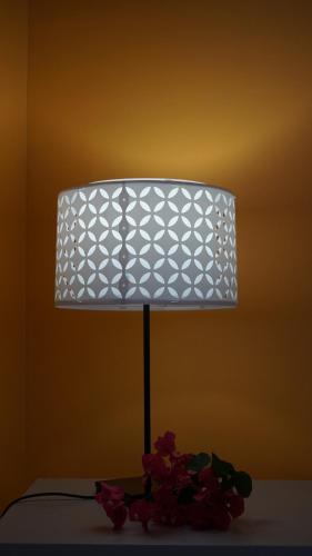 a lamp sitting on top of a table with flowers at Les Gites du Bonheur in Deshaies