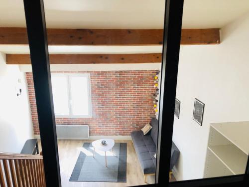 - un salon avec un mur en briques dans l'établissement Villa Royale - T1 bis de 31m2 - proche centre ville, à La Rochelle