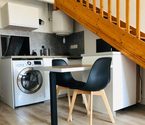 une cuisine avec une table et une machine à laver dans l'établissement Villa Royale - T1 bis de 31m2 - proche centre ville, à La Rochelle