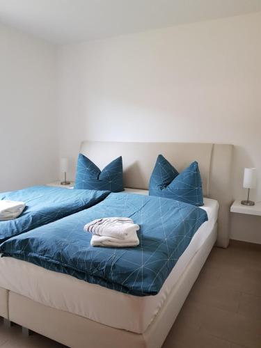 a bed with blue sheets and blue pillows at Ferienwohnung Fischer in Kurort Gohrisch