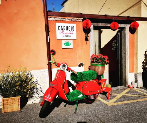 uma scooter vermelha estacionada em frente a um edifício em Carugio Remilde em La Spezia