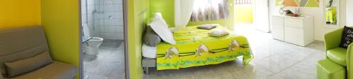 a bedroom with a yellow bed in a bathroom at Les Gites du Bonheur in Deshaies