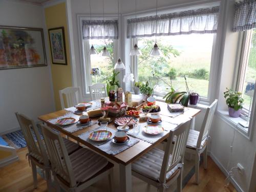 カトリーネホルムにあるSkogis Bed & Breakfastのダイニングルームテーブル(椅子、食べ物を入れたテーブル付)