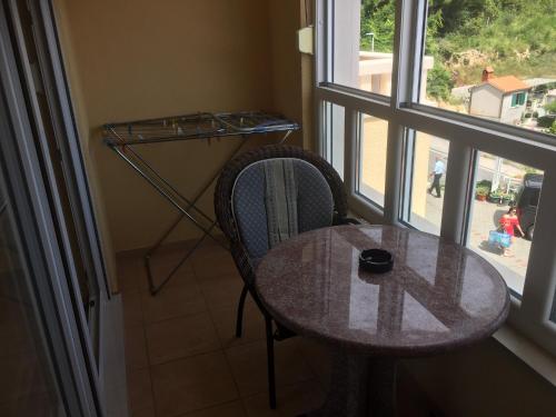 una mesa y una silla en una habitación con ventana en Apartments Villa Astra & Pinija, en Brela