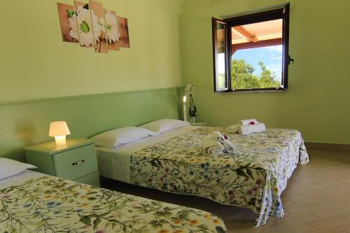 a hotel room with two beds and a window at Agriturismo Vulcano in Mirto Crosia