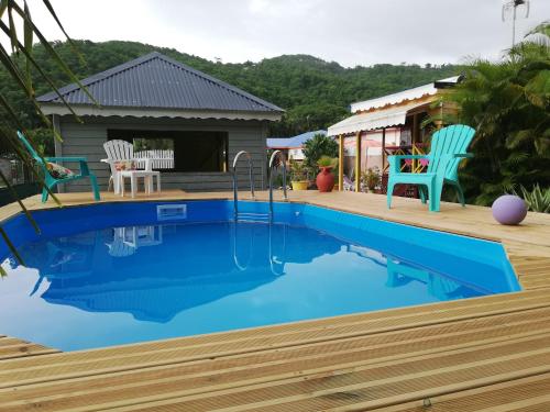 una piscina de agua azul en una casa en Au Sable D'Or - Spa - WIfi- Piscine en Deshaies