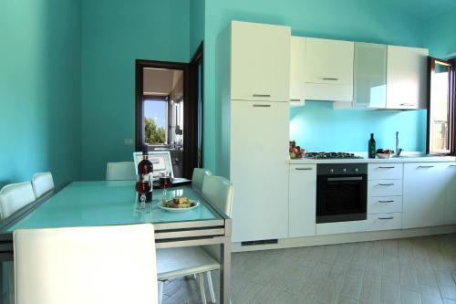 a kitchen with white cabinets and a blue wall at Agriturismo Vulcano in Mirto Crosia