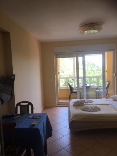 a bedroom with a bed and a table and a balcony at Apartments Villa Astra & Pinija in Brela