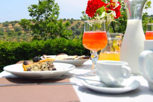 a table with a plate of food and a glass of orange juice at Agriturismo Vulcano in Mirto Crosia