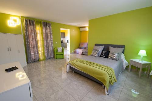 - une chambre avec un lit et un mur vert dans l'établissement Les Gites du Bonheur, à Deshaies