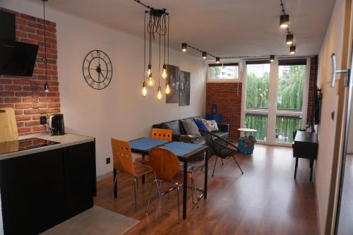 eine Küche und ein Wohnzimmer mit einem Tisch und Stühlen in der Unterkunft Apartament metro rondo Onz in Warschau