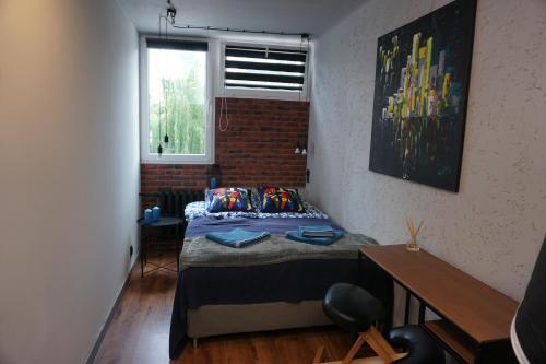 a bedroom with a bed and a brick wall at Apartament metro rondo Onz in Warsaw
