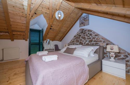 a bedroom with a large bed and a wooden ceiling at Holiday home Stipanovi Dvori with jacuzzi and pool in Zagvozd