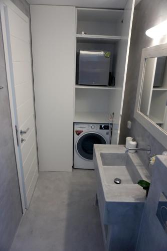 a bathroom with a sink and a washing machine at Sunset Villa I in Agia Irini Paros