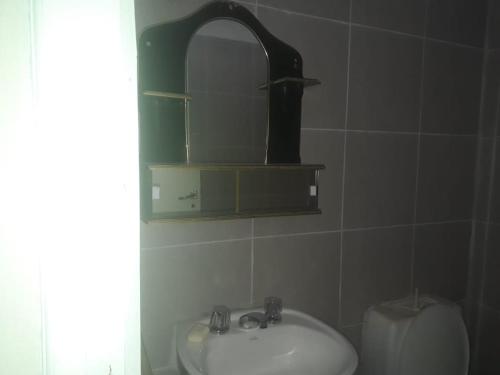 a bathroom with a sink and a mirror at Hostel Odorico in San José