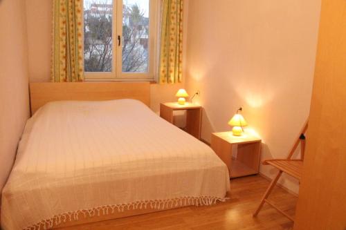 a bedroom with a bed and two lamps on two tables at Haus Mandarina in Rab
