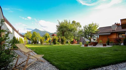 a yard with a chair in the grass at Landhotel Laudersbach in Altenmarkt im Pongau