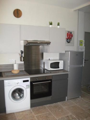 une cuisine avec un lave-linge et un micro-ondes dans l'établissement ST REMY DE PROVENCE PROCHE CENTRE VILLE - Parking privé, à Saint-Rémy-de-Provence