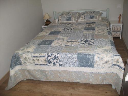 uma cama com uma colcha num quarto em ST REMY DE PROVENCE PROCHE CENTRE VILLE - Parking privé em Saint-Rémy-de-Provence