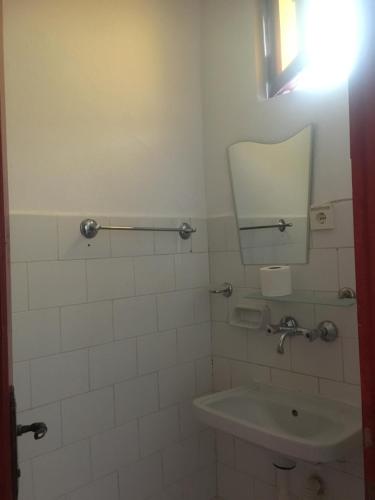 a bathroom with a sink and a mirror at Billur Pension in Cıralı