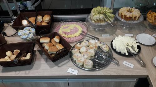 einen Tisch mit vielen verschiedenen Arten von Kuchen und Gebäck in der Unterkunft Angelo Hotel in Olímpia