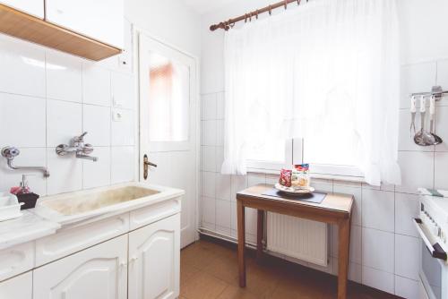 uma casa de banho branca com um lavatório e um espelho em Comfy & Relaxing Apartment em Tessalônica