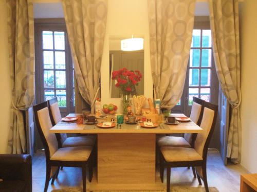 a dining room table with chairs and a vase of flowers at Casa do Má in Lisbon