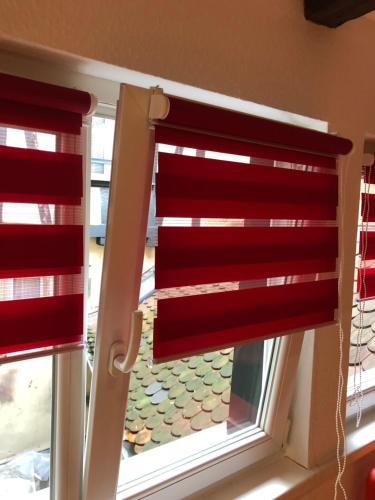 a window with a red curtain in a room at Cosy & quiet flat in historical lively center of Strasbourg in Strasbourg