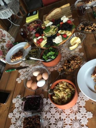 una mesa con muchos platos de comida. en Billur Pension, en Cıralı