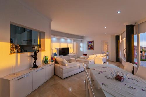ein Wohnzimmer mit weißen Möbeln und einem Tisch in der Unterkunft Villa Sara in Costa Adeje - Sara Vacation in Adeje