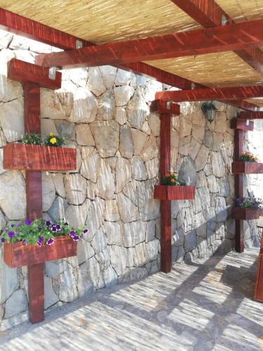 a stone wall with flower boxes on it at Apartments Malou in Baška Voda