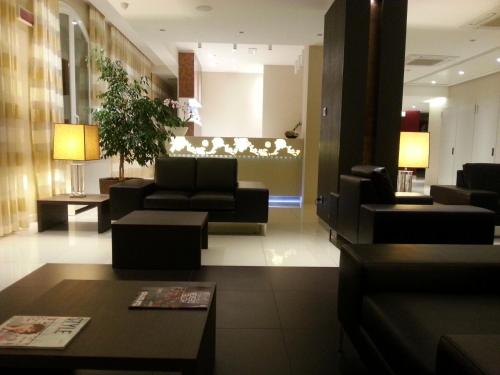 a lobby with couches and chairs and a table at Virginia Palace Hotel in Garbagnate Milanese