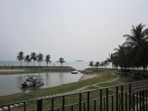 two boats are docked in a river with palm trees at Paradise Lagoon Apartment in Port Dickson