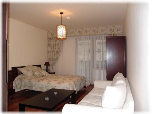 カジミエシュ・ドルニにあるApartament Pod Aniołem - Gdańskiのベッドルーム1室(ベッド1台、ソファ、テーブル付)