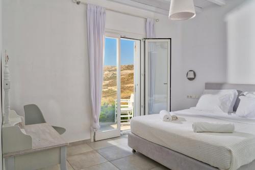 a white bedroom with a bed and a balcony at Elia Horizon Mykonos in Elia Beach