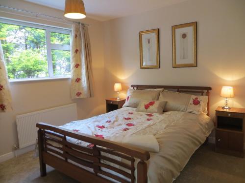 a bedroom with a bed with two lamps and a window at River View in Coleraine