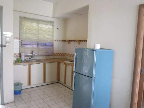 a kitchen with a blue refrigerator in a room at Paradise Lagoon Apartment in Port Dickson