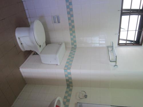 a bathroom with a toilet in a tiled room at Paradise Lagoon Apartment in Port Dickson