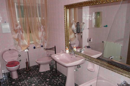 een badkamer met een wastafel, een toilet en een spiegel bij B&B La Mezza Luna in Messina