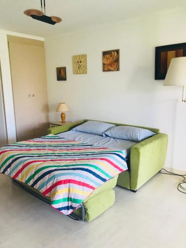 - une chambre avec un lit et une couverture colorée dans l'établissement French Riviera Deluxe near Nice airport, à Cagnes-sur-Mer