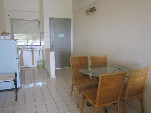 a dining room with a glass table and chairs at Paradise Lagoon Apartment in Port Dickson